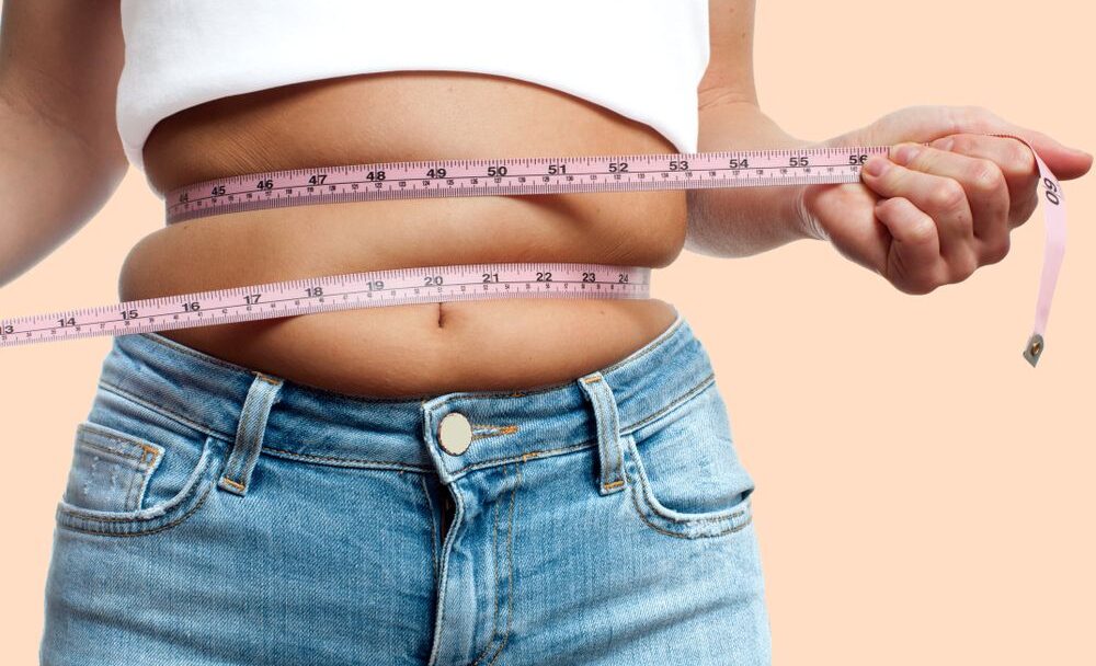 Overweight,Woman,With,Tape,Measure,Around,Waist,On,Pastel,Background